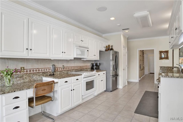 kitchen with white appliances, tasteful backsplash, white cabinets, and crown molding