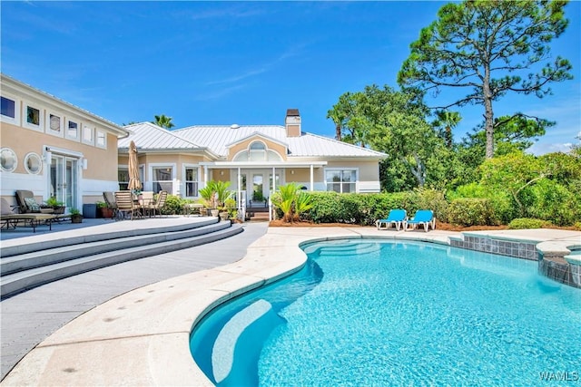 view of pool with french doors, a patio area, and a pool with connected hot tub