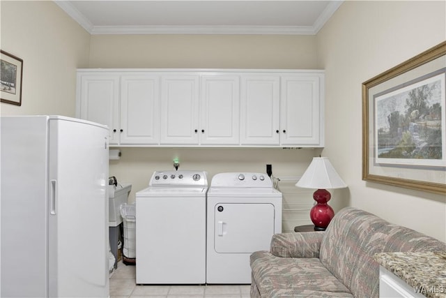 laundry area with ornamental molding, washer and clothes dryer, light tile patterned flooring, and cabinet space