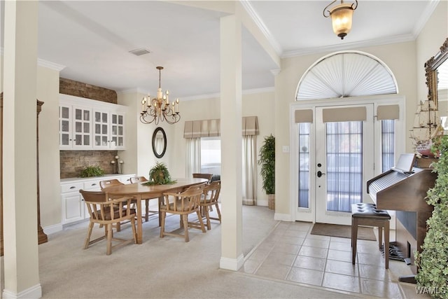 foyer entrance with plenty of natural light, visible vents, and crown molding