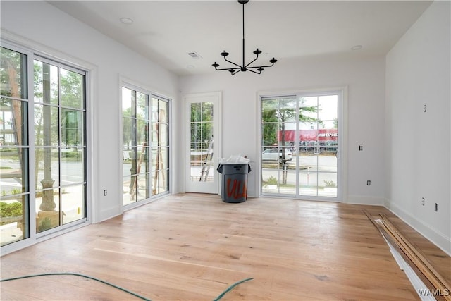 1300 Paul W Bryant Dr Unit 100, Tuscaloosa, AL 35401 - unfurnished dining area with healthy amount of natural light, a chandelier, and light wood-type flooring
