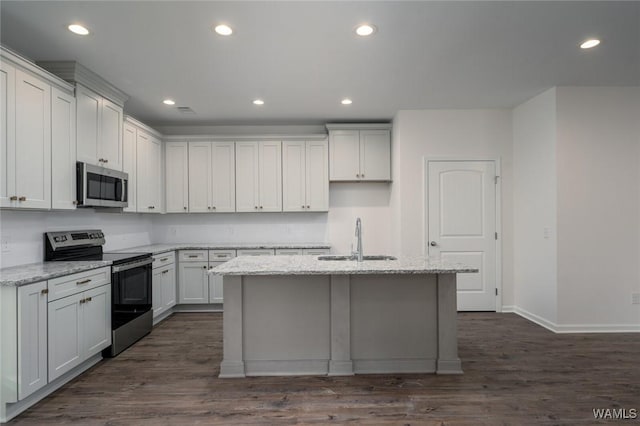 kitchen with white cabinetry, light stone countertops, sink, stainless steel appliances, and an island with sink