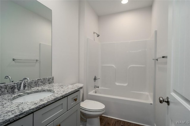 full bathroom featuring hardwood / wood-style floors, vanity, toilet, and tub / shower combination