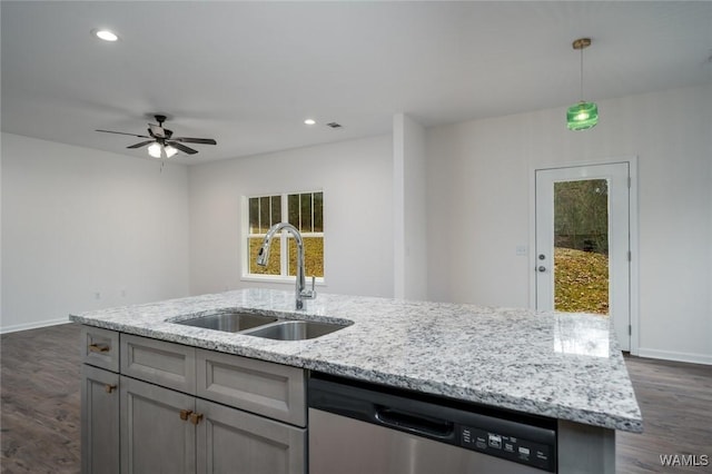 kitchen featuring pendant lighting, light stone counters, stainless steel dishwasher, and sink