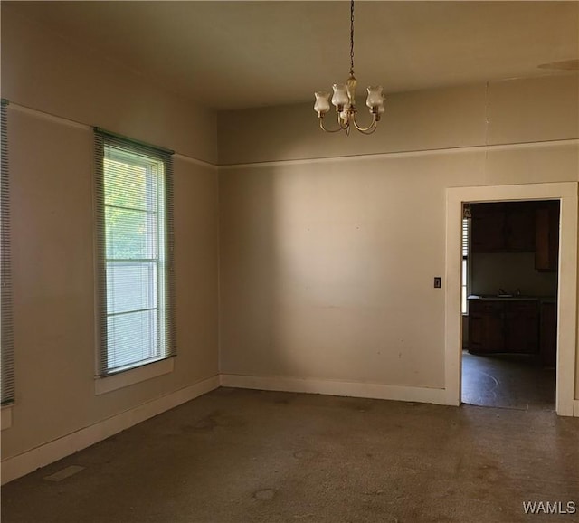 spare room featuring an inviting chandelier