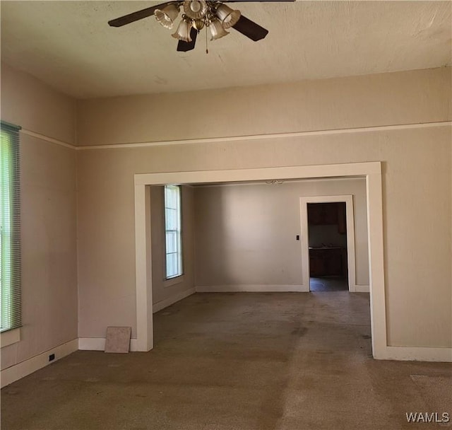 carpeted spare room featuring ceiling fan