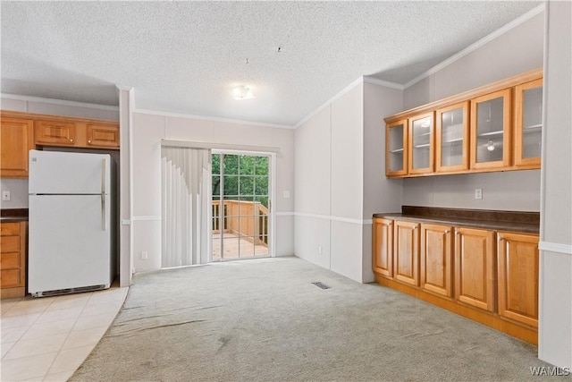 10463 Beulah Lake Ln, Cottondale, AL 35453 - kitchen featuring freestanding refrigerator, a textured ceiling, crown molding, glass insert cabinets, and brown cabinets