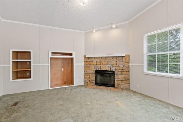 10463 Beulah Lake Ln, Cottondale, AL 35453 - unfurnished living room with ornamental molding, carpet, a stone fireplace, and a textured ceiling