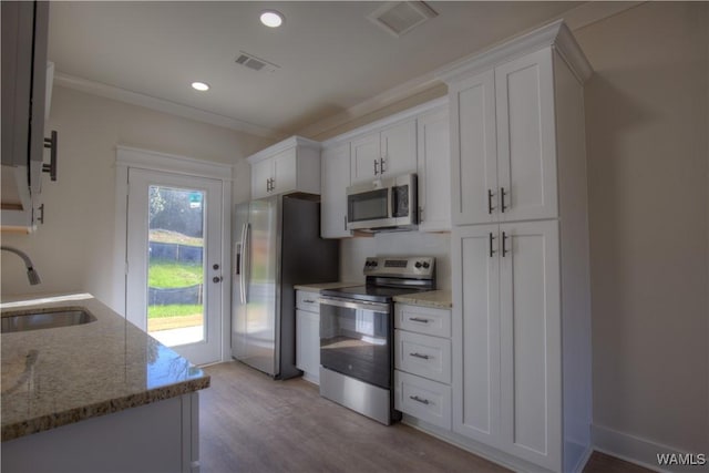 kitchen with visible vents, white cabinets, appliances with stainless steel finishes, and a sink