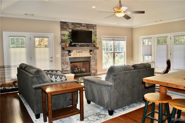 living room with ornamental molding, dark wood-type flooring, and a healthy amount of sunlight