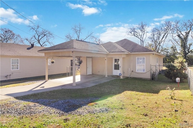 rear view of house featuring a yard and a carport