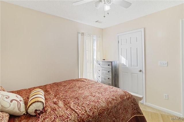 carpeted bedroom with ceiling fan and a textured ceiling