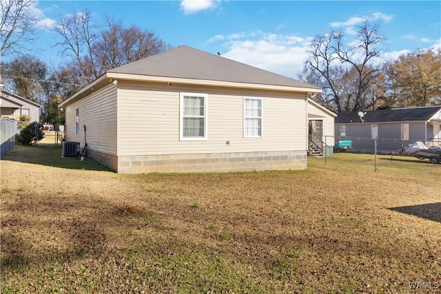 rear view of property featuring cooling unit and a yard