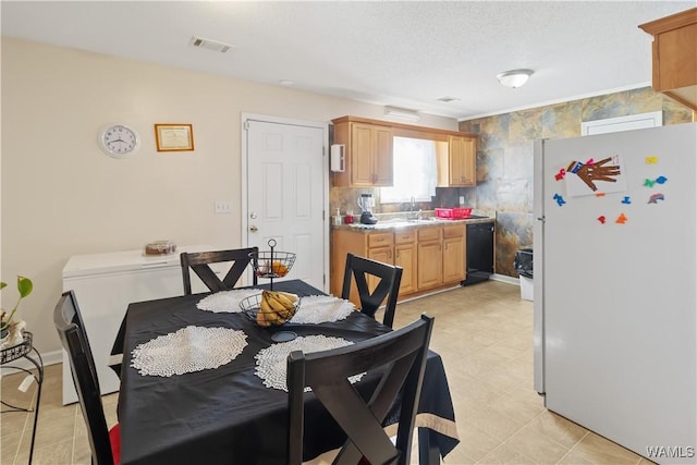 dining space featuring sink and a textured ceiling