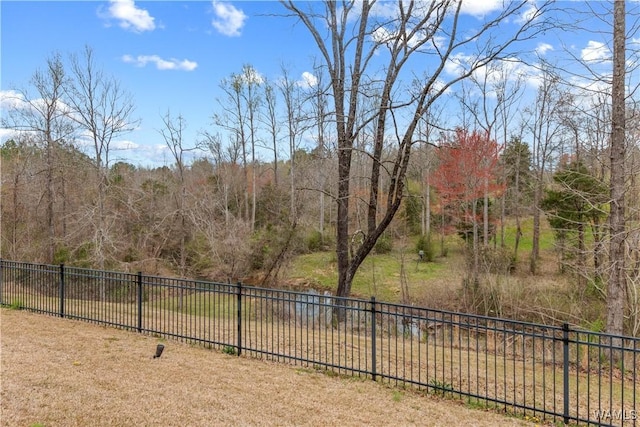 view of yard featuring fence and a view of trees