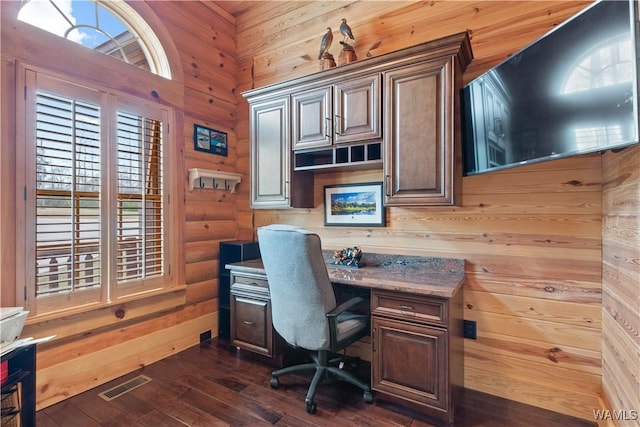 office with rustic walls, dark wood-style floors, visible vents, and a wealth of natural light