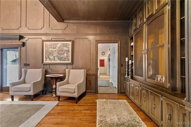 living area featuring wood walls, light hardwood / wood-style flooring, and wooden ceiling