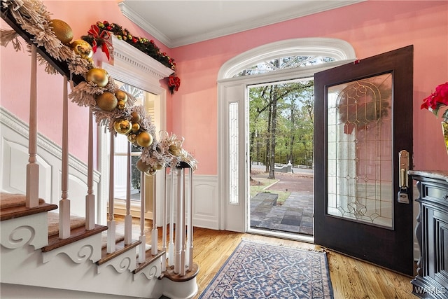 foyer with light wood-type flooring and ornamental molding