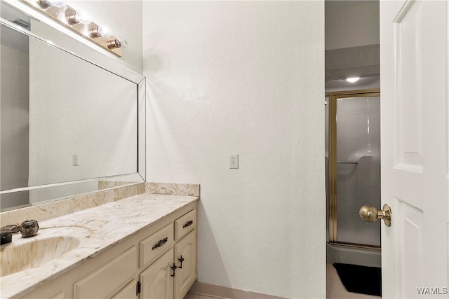 bathroom featuring tile patterned floors, vanity, and an enclosed shower