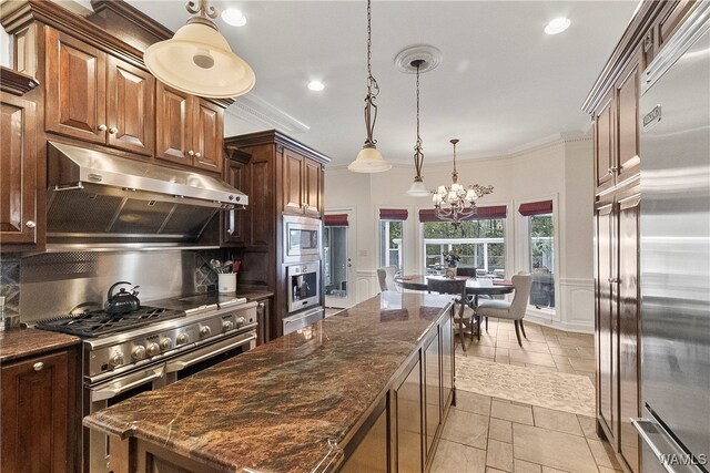 kitchen featuring built in appliances, dark stone counters, and tasteful backsplash