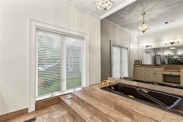 bathroom with a bathtub, vanity, an inviting chandelier, and ornamental molding