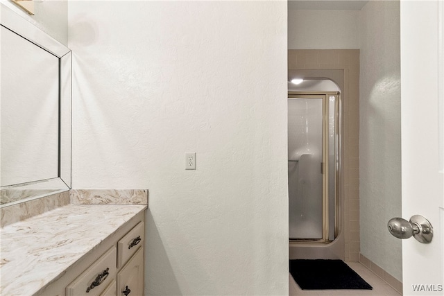 bathroom featuring vanity, tile patterned floors, and an enclosed shower