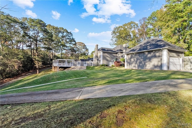 view of yard featuring a garage and a wooden deck