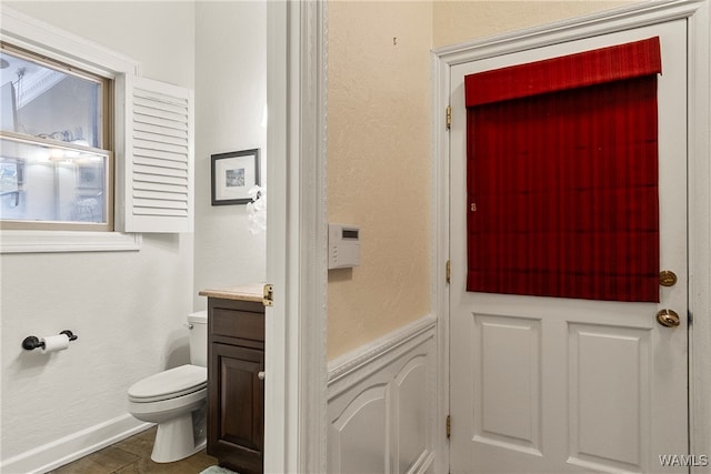 bathroom with tile patterned flooring, vanity, and toilet