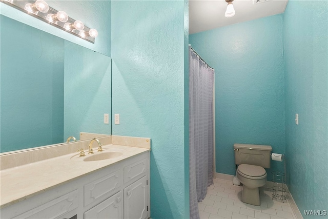 bathroom featuring tile patterned flooring, vanity, toilet, and curtained shower