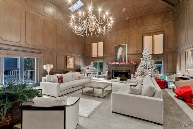 living room with a healthy amount of sunlight, a chandelier, and a high ceiling