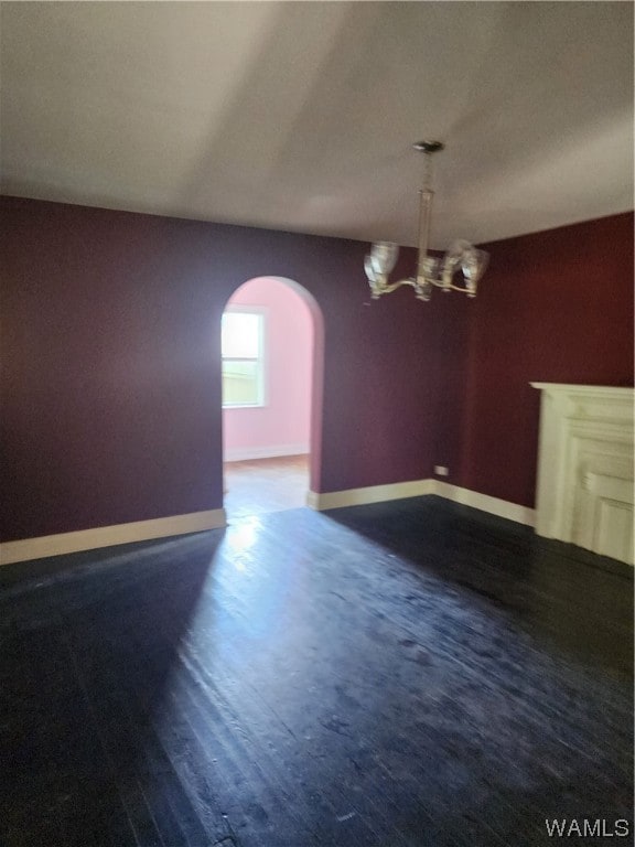 unfurnished dining area featuring a chandelier and dark hardwood / wood-style floors