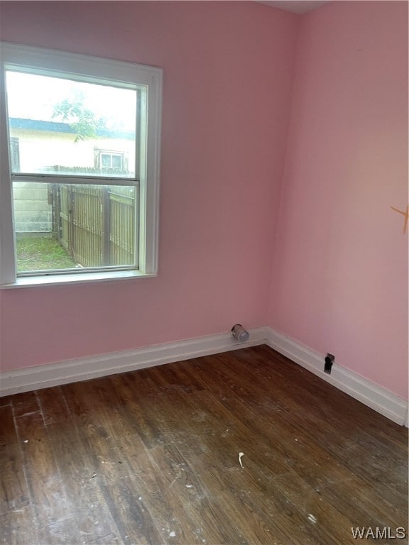 unfurnished room with a healthy amount of sunlight and dark hardwood / wood-style floors