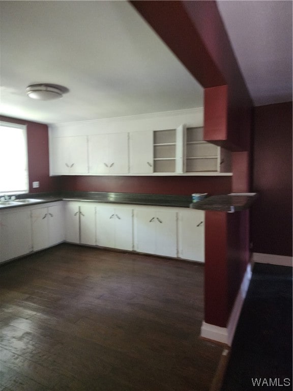 kitchen featuring dark hardwood / wood-style flooring, white cabinetry, and sink