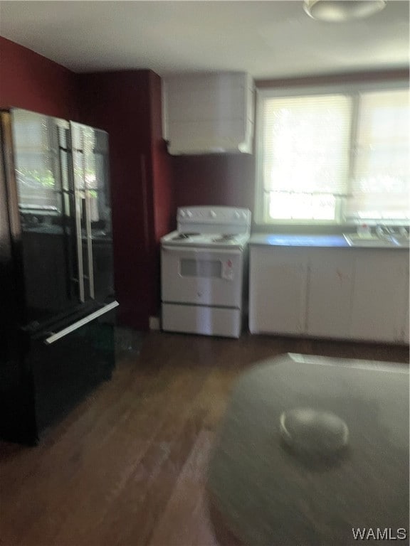 kitchen featuring white cabinets, hardwood / wood-style floors, and white range with electric cooktop