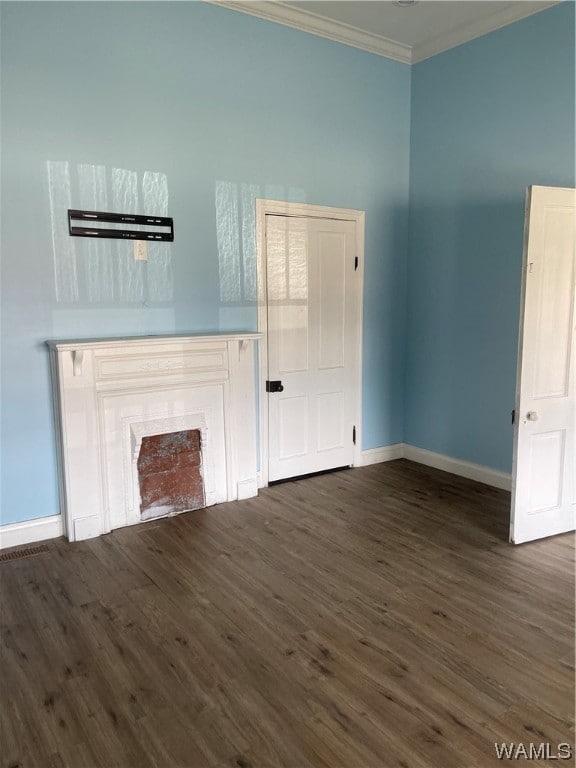 unfurnished living room featuring dark hardwood / wood-style floors and ornamental molding