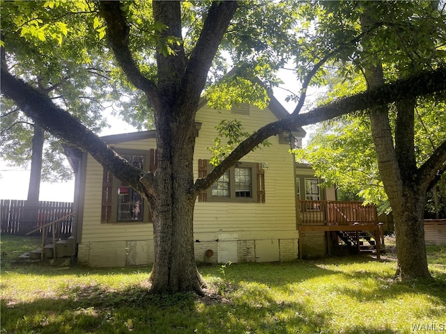 view of home's exterior featuring a wooden deck and a yard