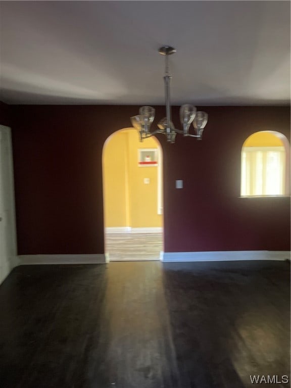 interior space with a notable chandelier and dark wood-type flooring