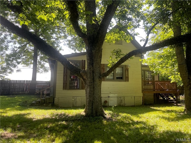 view of side of property with a lawn and a wooden deck