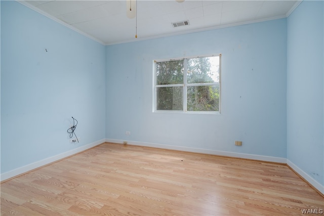 spare room featuring crown molding and light hardwood / wood-style floors