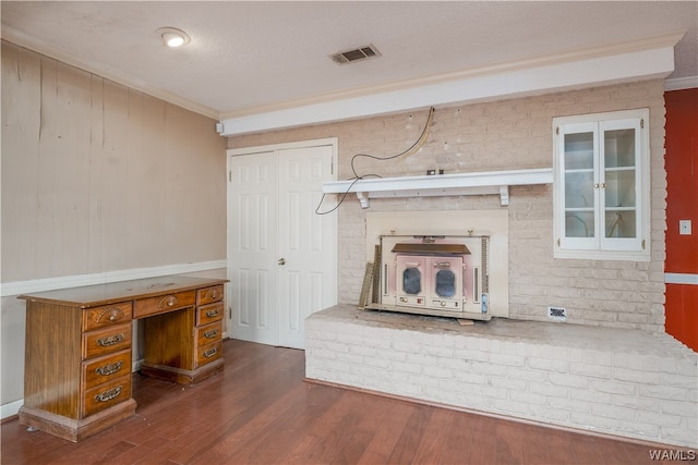 unfurnished living room featuring wood walls, dark hardwood / wood-style flooring, a textured ceiling, and ornamental molding