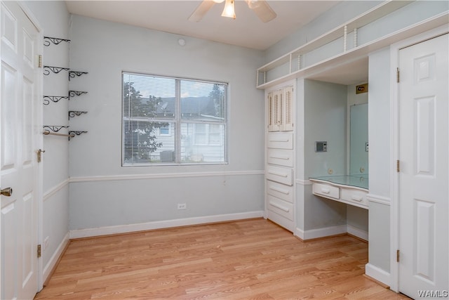 interior space featuring ceiling fan, built in desk, and light wood-type flooring