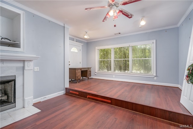 unfurnished living room with a fireplace, hardwood / wood-style floors, ceiling fan, and crown molding