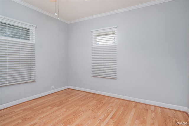 empty room with crown molding and light hardwood / wood-style flooring