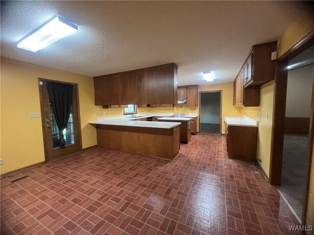 10882 Tingle Tangle Rd, Vance, AL 35490 - kitchen featuring a breakfast bar, sink, kitchen peninsula, and a textured ceiling