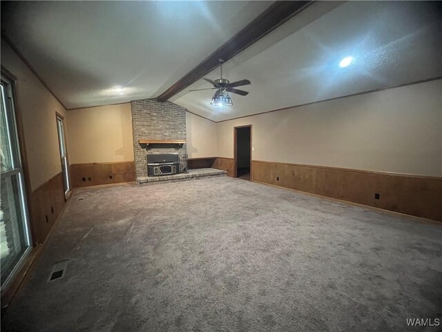 10882 Tingle Tangle Rd, Vance, AL 35490 - unfurnished living room featuring ceiling fan, lofted ceiling with beams, wood walls, carpet floors, and a fireplace