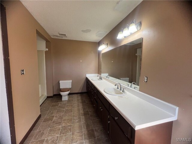 10882 Tingle Tangle Rd, Vance, AL 35490 - bathroom featuring vanity, a textured ceiling, and toilet