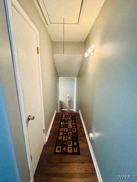 corridor with attic access, wood finished floors, and baseboards