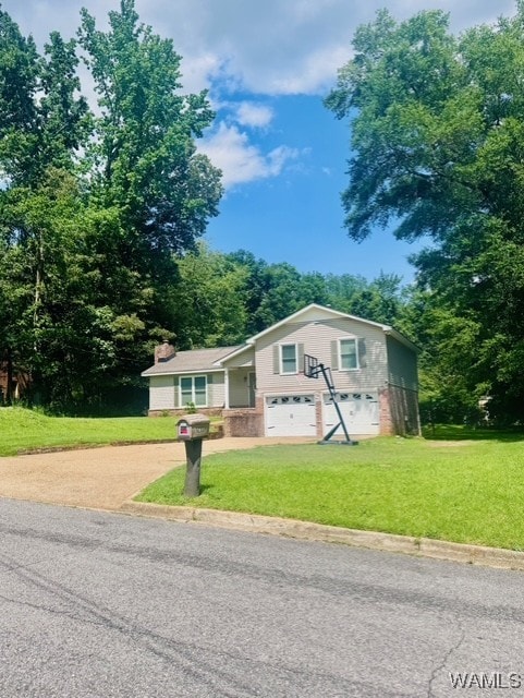 tri-level home featuring concrete driveway, an attached garage, a front lawn, and a chimney