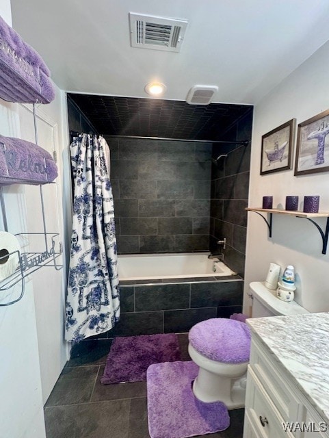 bathroom featuring tiled shower / bath, toilet, vanity, and tile patterned floors