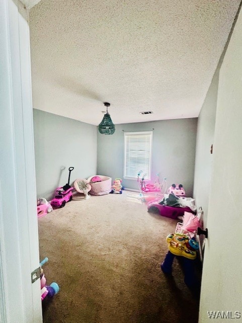 recreation room featuring carpet floors and a textured ceiling